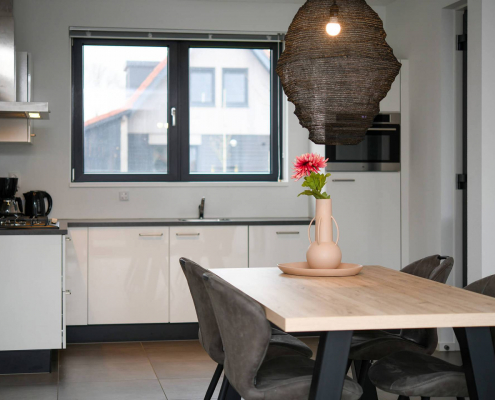 Küche mit weißen schubladen schwarzer arbeitsplatte und ofen sowie ein kühlschrank